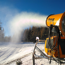 Snow cannon producing artificial snow on a ski slope.