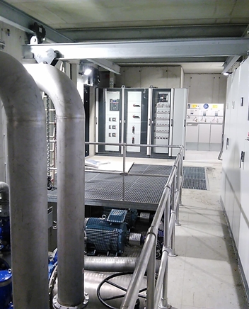 Technischer Raum mit Rohrleitungen und Schaltschränken.